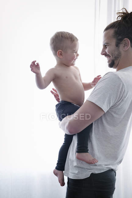 Uomo con in braccio un bambino piccolo — Foto stock