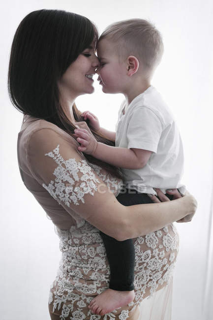 Беременная женщина держит сына — стоковое фото