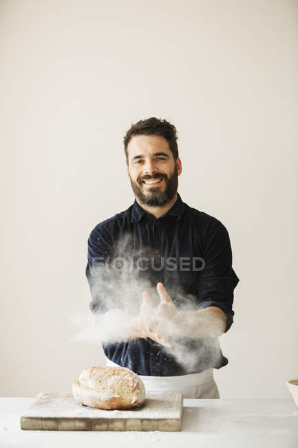 Baker wiping his floury hands — Stock Photo