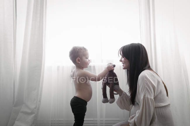 Беременная женщина играет с сыном — стоковое фото