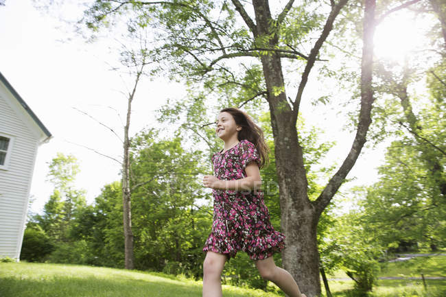 Girl running across grass — Stock Photo