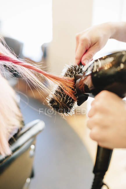 Hair stylist blowdrying hair — Stock Photo