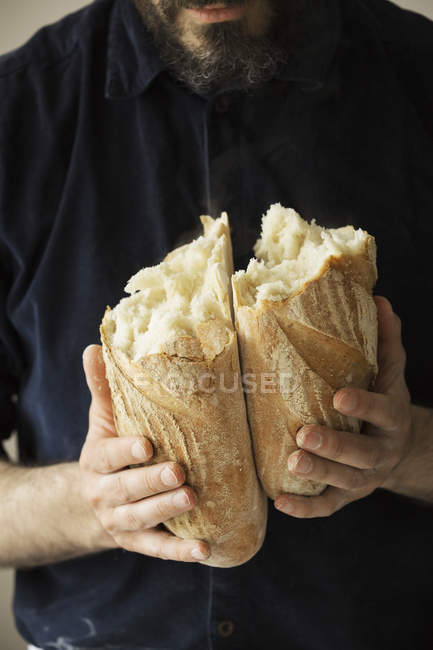 Padeiro segurando um pão de pão. — Fotografia de Stock
