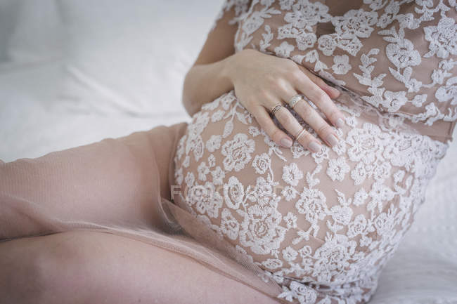 Mulher com a mão na barriga grávida — Fotografia de Stock