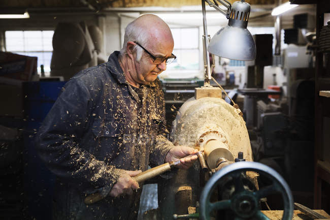 Homme avec machine à bois dans un atelier de menuiserie — Photo de stock