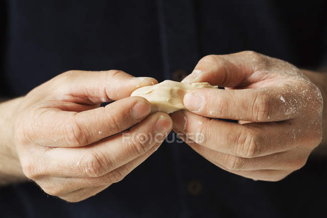 Baker holding pieces of fresh yeast — Stock Photo