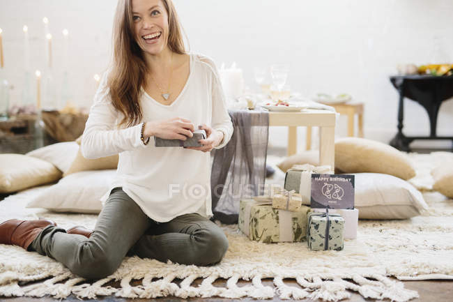 Woman sitting on ground holding gift — Stock Photo