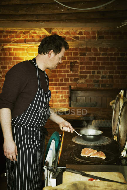 Chef cooking fish on stove. — Stock Photo