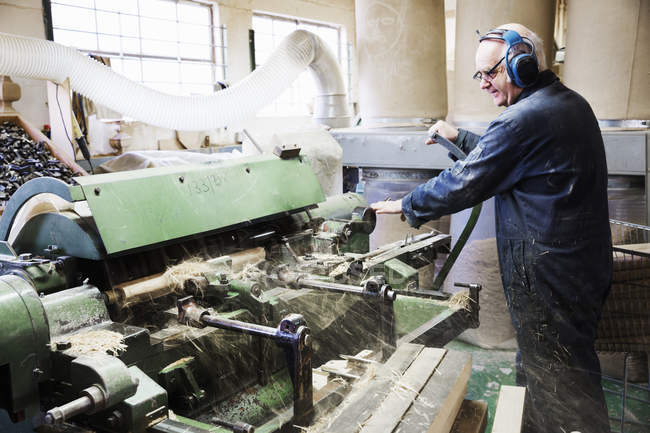 Uomo che lavora in una macchina per la lavorazione del legno . — Foto stock