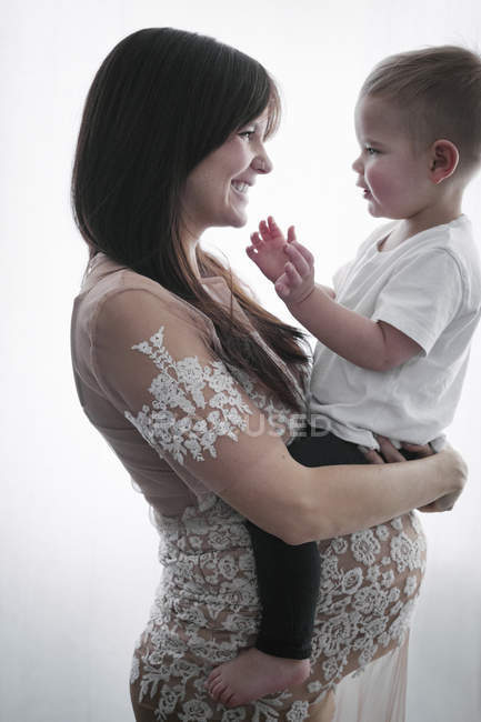 Embarazada mujer sosteniendo hijo - foto de stock
