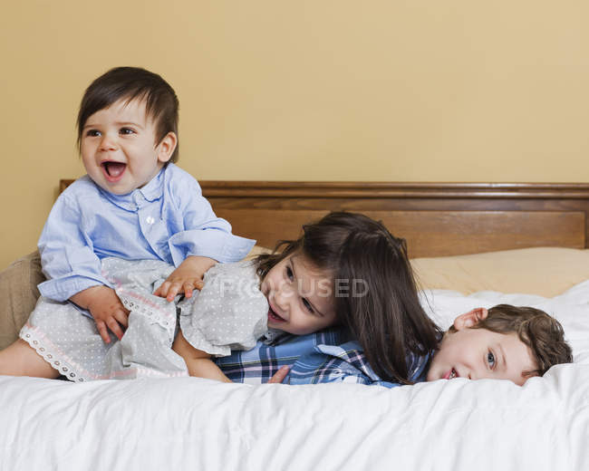 Crianças brincando na cama — Fotografia de Stock