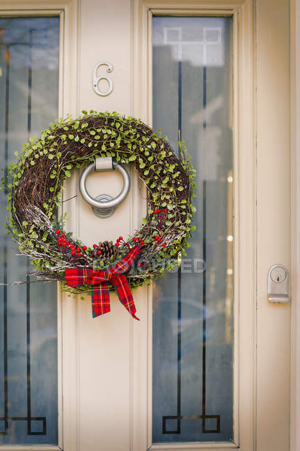 Corona de Navidad en la puerta principal - foto de stock