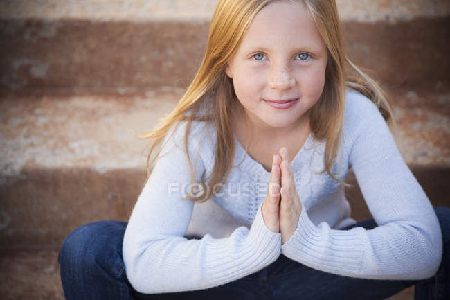 Jeune fille assise sur les marches — Photo de stock