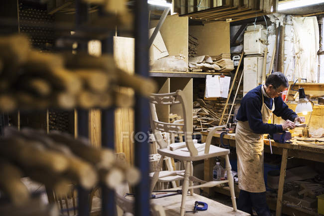 Человек, работающий в столярной мастерской — стоковое фото
