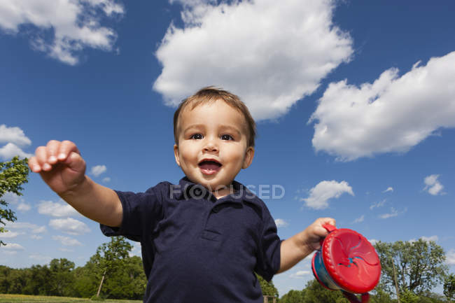 Niño sosteniendo taza roja - foto de stock