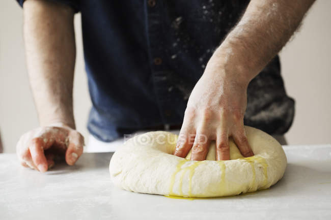 Пекарь месит большое хлебное тесто . — стоковое фото