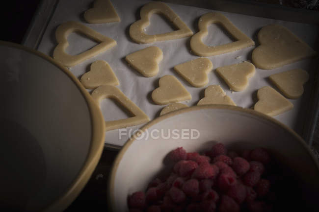 Ciotola di lamponi e biscotti a forma di cuore — Foto stock