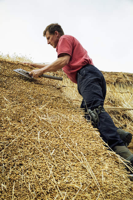 Man thatching roof — Stock Photo