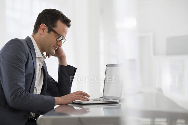 Hombre de negocios utilizando ordenador portátil - foto de stock