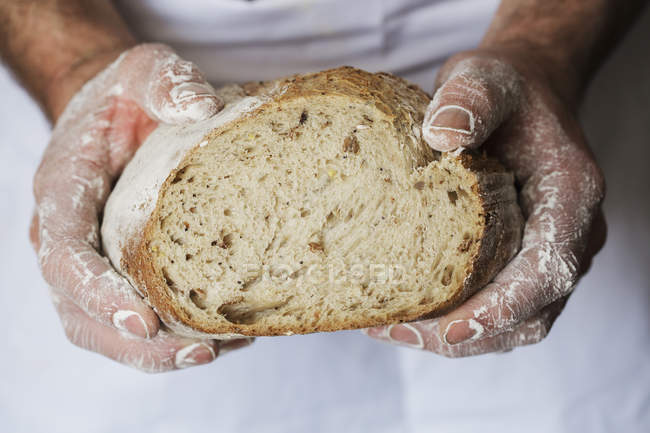 Baker holding loaf of bread. — Stock Photo
