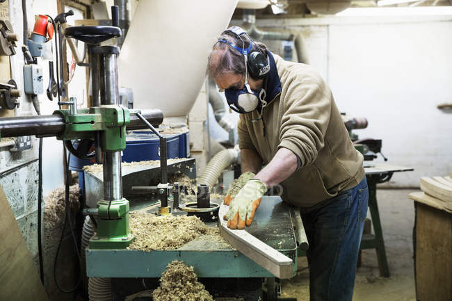 Hombre trabajando en un pedazo de madera
. - foto de stock