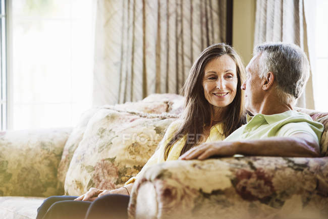 Старший пара, сидячи на дивані. — стокове фото