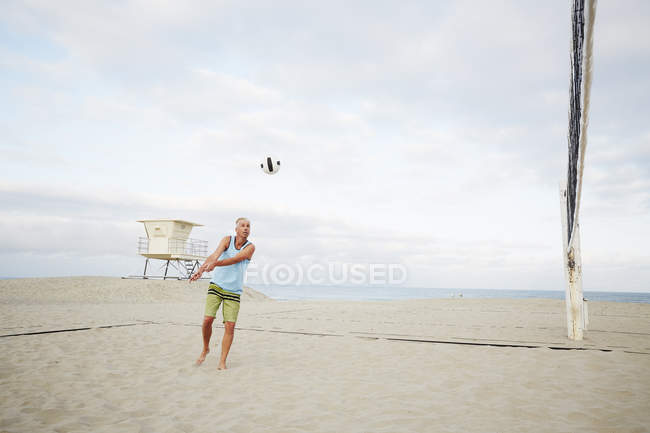 Reifer Mann spielt Beachvolleyball. — Stockfoto