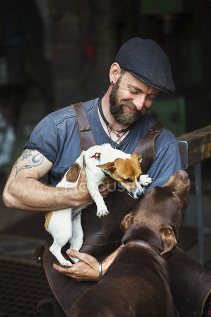 Man with two dogs in a workshop. — Stock Photo
