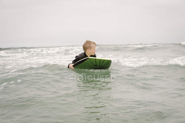 Boy bodyboarding in ocean — Stock Photo