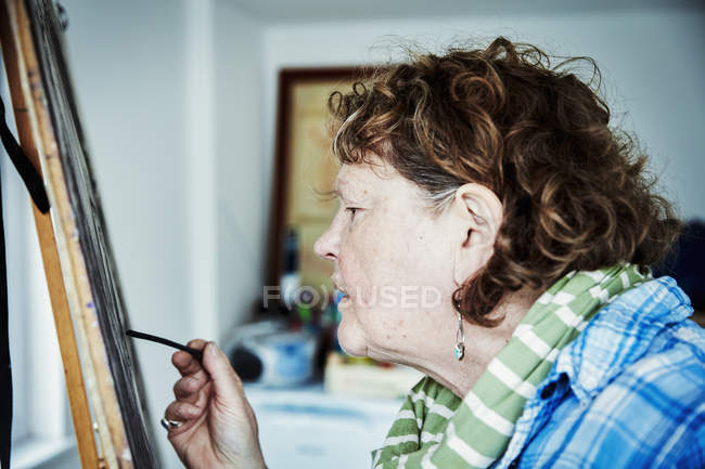 Artist working at easel — Stock Photo