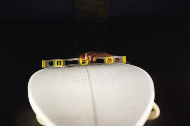 Surfboard in a workshop with a spirit level — Stock Photo