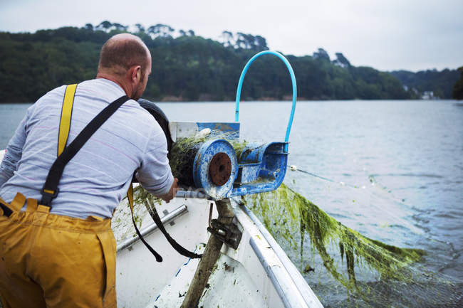 Pescador devanado en la red de pesca - foto de stock