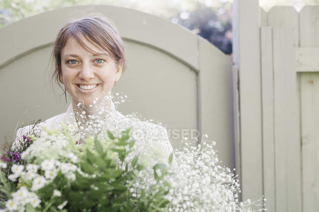 Donna che trasporta un mazzo di fiori bianchi
. — Foto stock