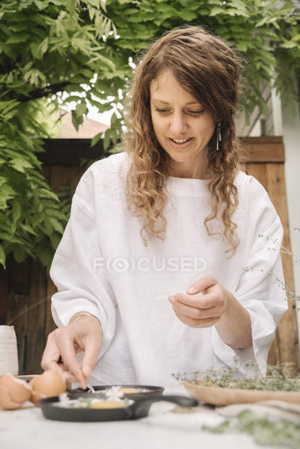 Mujer preparando huevos para el desayuno. - foto de stock