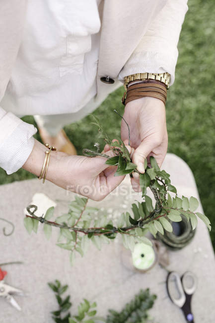 Frau bastelt einen Blumenkranz. — Stockfoto