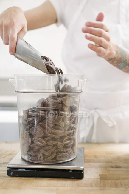 Woman weighing chocolate in bakery — Stock Photo