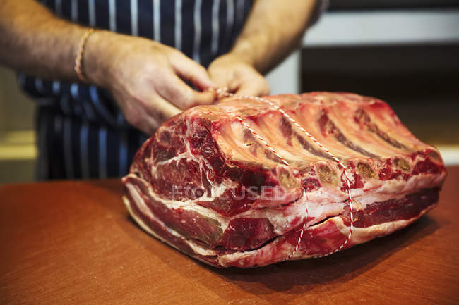 Carnicero preparando gran pedazo de carne de res - foto de stock