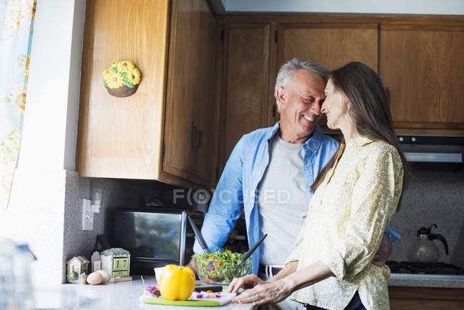 Sorridente coppia anziana in una cucina — Foto stock