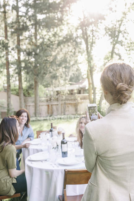 Woman taking a photograph of friends — Stock Photo