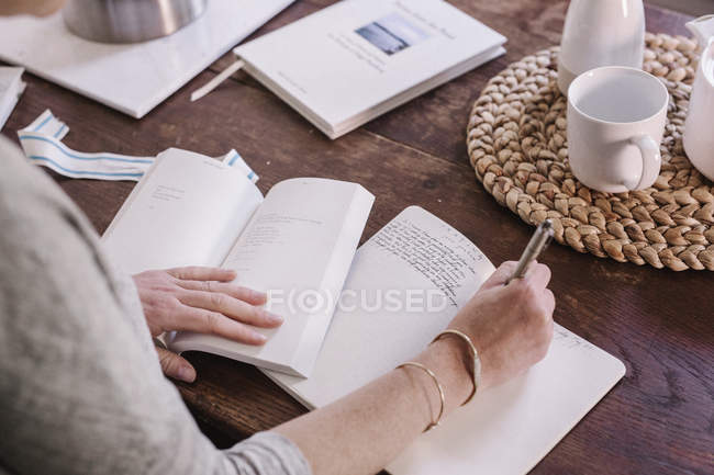 Mujer escribiendo en un diario - foto de stock