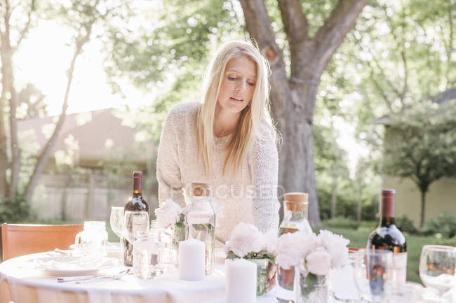 Mulher colocando uma mesa em um jardim — Fotografia de Stock