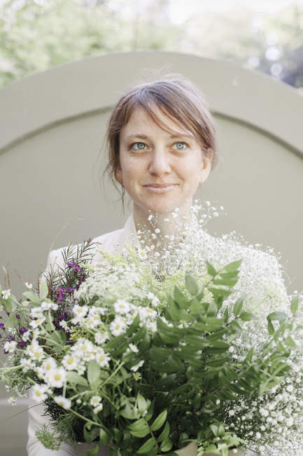 Femme portant un bouquet de fleurs blanches . — Photo de stock