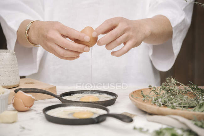 Donna che prepara uova per la colazione. — Foto stock