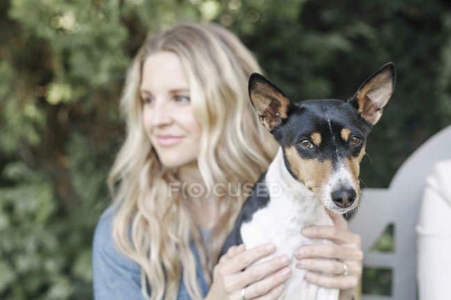 Woman sitting on a bench with dog — Stock Photo