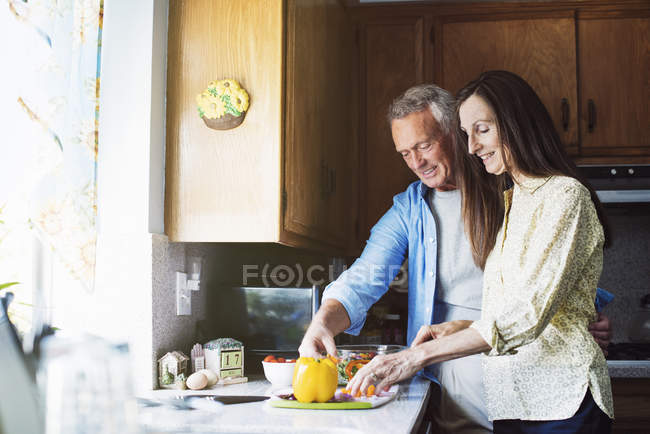 Sonriendo pareja mayor en una cocina - foto de stock