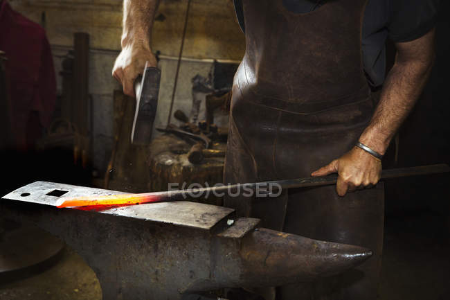 Коваль вражає довжину гарячого металу — стокове фото