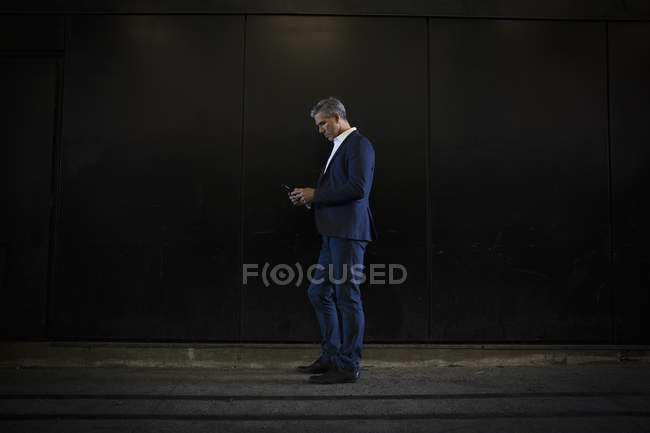 Empresário de pé na sombra na rua da cidade — Fotografia de Stock