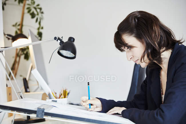 Mujer trabajando en un gráfico en un tablero de dibujo - foto de stock