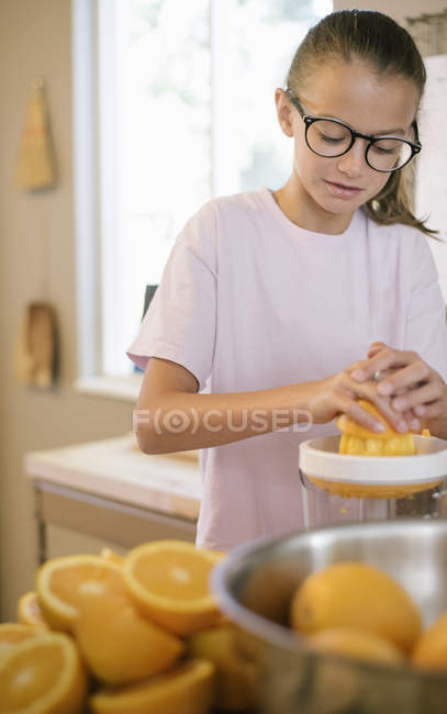 Девушка сжимает апельсины — стоковое фото