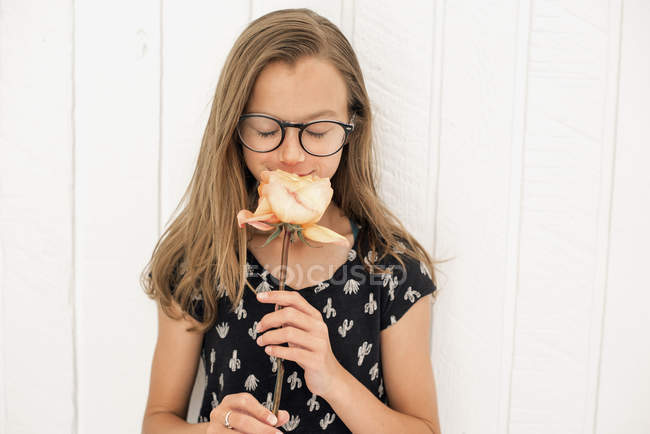 Menina cheirando uma rosa — Fotografia de Stock